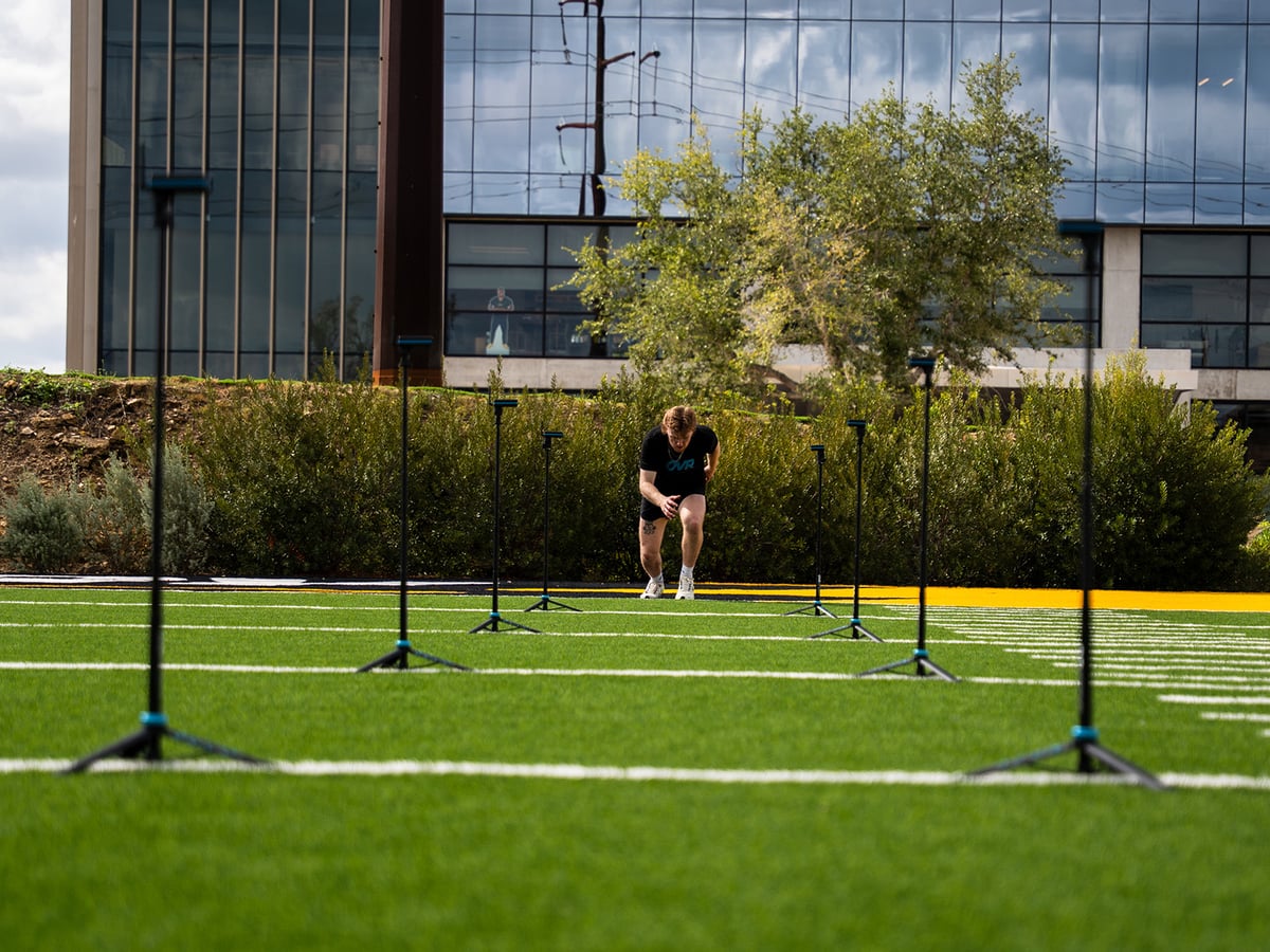High school athletes running timed 40s at practice.